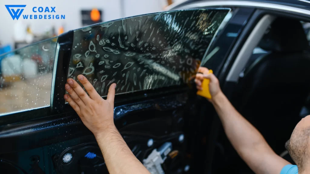 Another image showing the final adjustments of tint film on a car window, tying into "how much to tint car windows."